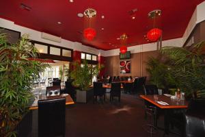 a restaurant with tables and chairs and potted plants at Mandurah Motel and Apartments in Mandurah