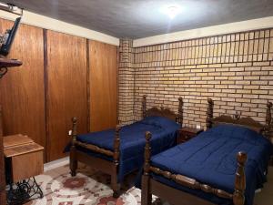 a bedroom with two beds and a brick wall at Departamento Nuevo Céntrico Las Marías 2 in Saltillo