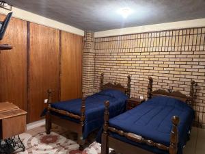 Departamento Nuevo Céntrico Las Marías 2 في سالتيلو: غرفة نوم بها سريرين وجدار من الطوب