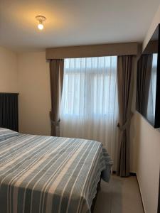 a bedroom with a bed and a window with curtains at Apartamento en zona 11 Ciudad Guatemala, Cerca de Miraflores in Guatemala