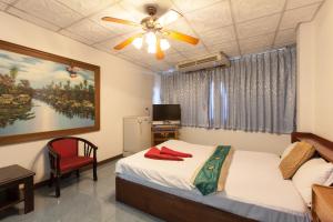 1 dormitorio con 1 cama y ventilador de techo en The Encore Hotel, en Pattaya South