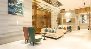 City Comfort Inn Nanning Guangxi University for Nationalities في نانينغ: لوبي فيه كنب وكراسي في غرفة