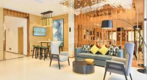 City Comfort Inn Wuhan Tianhe Airport Outlets في ووهان: غرفة معيشة مع أريكة زرقاء وطاولة