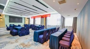 una sala de conferencias con mesas azules y sillas moradas en Echarm Hotel Wuhan High-speed Rail Peace Park Metro Station, en Wuhan