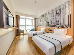 City Comfort Inn Chengdu Southwest University of Finance and Economics Wansheng Metro Station في تشنغدو: غرفة فندق بها سريران وطاولة +64 صورة