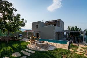 une arrière-cour avec une piscine et une maison dans l'établissement Traditional Stonebuilt Villa Leonanto, only 5 Km from a Sandy Beach, à Kástellos