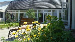 eine Bank vor einem Wintergarten mit gelben Blumen in der Unterkunft Terasa in Stanishovka