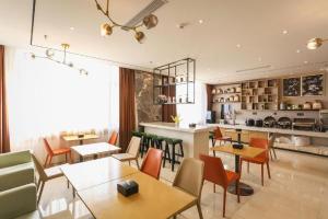City Comfort Inn Chengdu Wenjiang Zhujiang Square Guanghua Park Metro Station في تشنغدو: مطعم به طاولات وكراسي ومنضدة