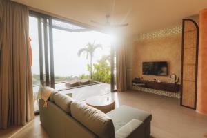ein Wohnzimmer mit Couch und großem Fenster in der Unterkunft Cactus Village Penida in Nusa Penida