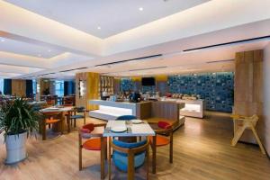 a restaurant with tables and chairs and a bar at Magnotel Hotel Guangyuan Nanhe Bus Station Beijing Road in Guangyuan