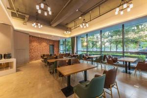um restaurante com mesas, cadeiras e janelas em James Joyce Coffetel Tianjing First Central Hospital Nankai University em Tianjin