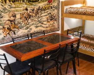 tavolo e sedie in una stanza con un quadro di Brisas Serranas Departamentos a Villa Carlos Paz