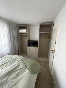 een slaapkamer met een bed en een televisie. bij Gustavs Rooftop in Oldenburg