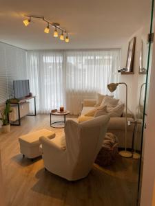 een woonkamer met een bank en stoelen bij Gustavs Rooftop in Oldenburg