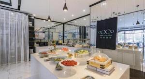 um restaurante com um buffet de comida no balcão em Xana Lite Hotelle Tianjin Huaming Binhai International Airport em Tianjin