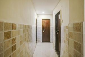 a hallway with two doors and a tiled wall at Hotel O Gymkhana Dombivli Mumbai in Dombivli