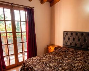 una camera da letto con un letto e una grande finestra di Brisas Serranas Departamentos a Villa Carlos Paz