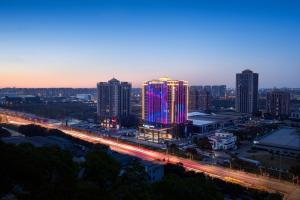 Un horizonte de ciudad con edificios iluminados y una autopista en Wyndham Garden Shanghai Songjiang, en Shanghái