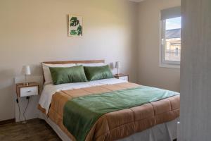 a bedroom with a large bed with green pillows at Femiba in El Calafate