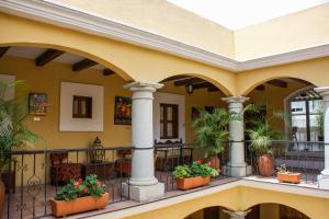 a large building with a balcony and a patio area at Hotel Casa Divina Oaxaca in Oaxaca City