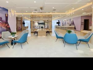 um átrio com cadeiras azuis, uma mesa e um balcão em Green Tree Inn Tianjin Dongli District Airport Free Trade Zone em Tianjin