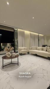 un soggiorno con due divani e un tavolino da caffè di شاليه وجد a Shaqra Altre 9 foto