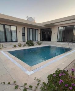 una piscina davanti a una casa di شاليه وجد a Shaqra
