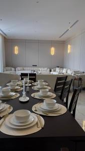 un lungo tavolo nero con piatti e tovaglioli sopra di شاليه وجد a Shaqra