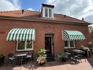 ein Backsteingebäude mit Tischen und Stühlen davor in der Unterkunft B&B In de Kathoek in Blokzijl