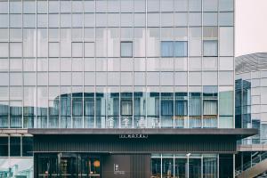 a tall building with a lot of windows at JI Hotel Shanghai Pudong Airport Zhuqiao in Nanhui