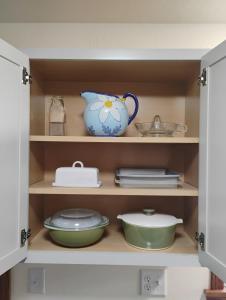 ein Schrank voller Geschirr und ein blauer Krug in der Unterkunft 5 blocks from the hospital! in Bismarck