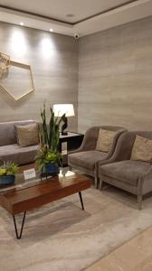 ein Wohnzimmer mit zwei Sofas und einem Couchtisch in der Unterkunft Sea Residences Moa Staycation- EVEREST in Sampong