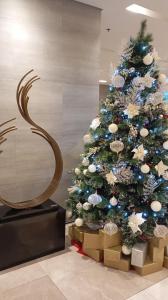 ein Weihnachtsbaum mit Geschenken darunter in der Unterkunft Sea Residences Moa Staycation- EVEREST in Sampong