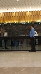 Eine Frau steht an einem Tisch in einem Gebäude in der Unterkunft Sea Residences Moa Staycation- EVEREST in Sampong