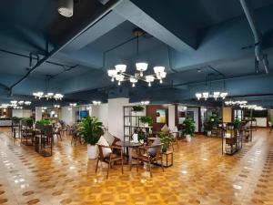 VX Hotel Chengdu Wenjiang Guosetianxiang Chenyue في تشنغدو: غرفة كبيرة بها طاولات وكراسي وزخارف