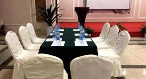 VX Hotel Chengdu Wenjiang Guosetianxiang Chenyue في تشنغدو: طاولة مع كراسي بيضاء وطاولة سوداء وبيضاء