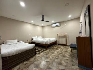 a bedroom with two beds and a ceiling fan at Narayani view resort in Bharatpur