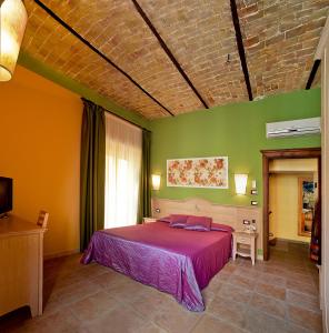 um quarto com uma cama roxa e paredes verdes em B&B Liu' Palazzo Ducale em Lesina