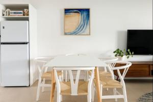 a white table and chairs in a kitchen with a refrigerator at 2-Bedroom Charm near Mater Hospital Pimlico Townsville in Aitkenvale