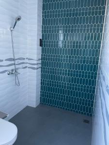 une salle de bain avec une douche carrelée bleue avec toilettes dans l'établissement Habi Homestay Doc Let, 