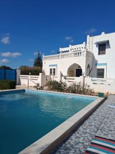 a villa with a swimming pool in front of a house at Antonie in Midoun