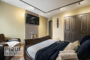 En eller flere senge i et værelse på Urban Oasis - with 16ft Swim Spa - Heated Hot Tub & Pool + 63 billeder