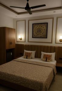 una camera con un grande letto e un ventilatore a soffitto di Khas Mahal Homestay ad Agra