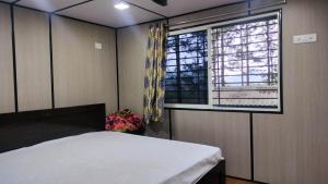 une chambre avec un lit et une fenêtre dans l'établissement Rr resort, à Araku