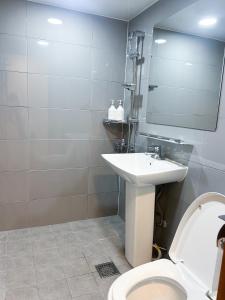 Un baño con inodoro, lavabo y espejo. en 포켓서울 문래점, en Seúl