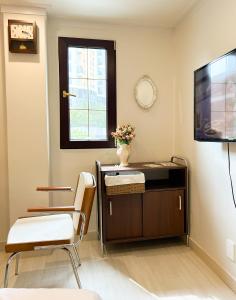 Una sala de estar con televisión, mesa y sillas. en 포켓서울 문래점, en Seúl
