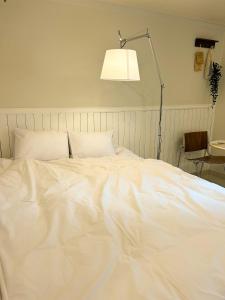 Cama blanca en habitación con lámpara en 포켓서울 문래점, en Seúl