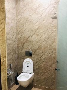 a bathroom with a toilet and a stone wall at Hotel Ram Ghar - Near Mathura Junction Railway Station in Mathura