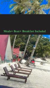 a group of benches sitting on the beach at DEWATI ROOMSTAY B&B in Lang Tengah