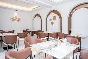 a dining room with tables and chairs and arched windows at فندق ارجان بارك جدة in Jeddah
